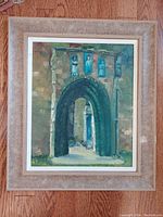 Framed original oil on board painting showing an arched sandstone doorway with visible architectural details and depth through the corridor beyond.