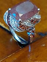 Close-up angle of ring showing rectangular faceted Tanzanian Natronite and surrounding white and brown zircon accents on platinum plated sterling silver band.