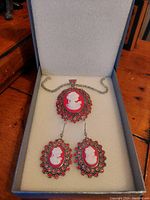 Set of cameo earrings and necklace in presentation box, showing overall design and color.