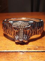 Close-up front view of silver finished tiger face bracelet with inset white Austrian crystals.