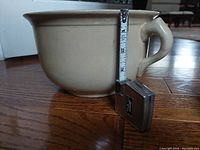 Side view of Medalta pottery bowl showing single handle and height measurement of about 5.5 inches