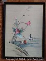 Front view of artwork showing embroidery of pink lilies and water fowl in water on beige silk fabric under glass in wood frame
