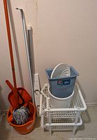 Mop set includes mop, orange bucket with wringer, orange dustpan, small broom, white stacking bins with blue bin, white coat rack and curtain rod