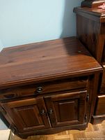 Front view of the wood night stand showing top surface, drawer, and cabinet doors closed.