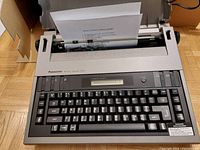 Front view of Panasonic KX-R200 electronic typewriter with paper loaded and keyboard visible.