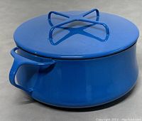 Front view of blue casserole with lid and side handle visible