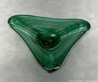 Top view showing triangular shape and aventurine inclusions in green glass bowl.