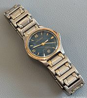 Full view of the vintage Gruen wrist watch showing the linked stainless steel band and round blue dial with gold-tone hands and markers.