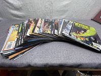 Full spread of 65 different Wolverine comic books fanned out on a surface.