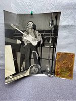Black and white photo showing Jimi Hendrix playing guitar on stage with CHUM FM microphone stand and Marshall amplifier in background, and original concert ticket.