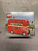 Front view of the new Lego Creator London Bus Mini set (40220) in its original box showing the assembled red double-decker bus model.