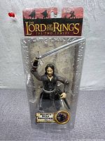 Front view of the new Lord of the Rings Helm's Deep Aragorn action figure in original packaging, 6-8 inches tall, packaged with swords and detailed armor.