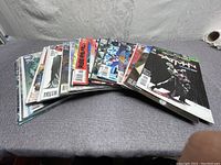 Multiple comic books arranged side by side on a gray textured surface.