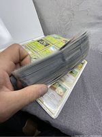 Side view of thick collection of Pokémon trading cards in plastic sleeves within a binder.
