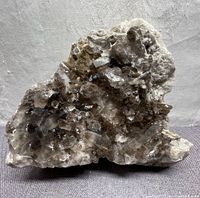 Single large piece of smokey quartz crystal cluster on rock matrix, showing crystals with natural terminations and translucent brownish-grey color.