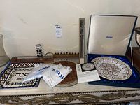 Overview photo showing all items together on a decorative table including the menorah, trays, cutter, Spode Passover plate in box, and ceramic dish.