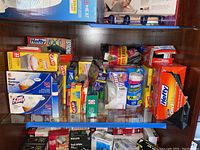 Full shelf of assorted trash bags and storage bags including Hefty, Glad, Pure Power, Ziploc, and Lawn & Leaf brands.
