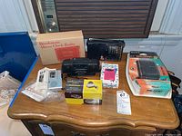 Photo of entire lot on wood table, showing all items with boxes and loose electronics