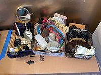 Overall view of three wire baskets with assorted vintage vanity items including mirrors, compacts, cases, pouches and clutches