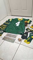 Shows full lot with jersey, scarf, gloves, socks, beanie, cup, pin, and team photo.