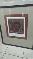 Full view of framed art piece showing the entire artwork with frame and matting, capturing minor scuff on frame