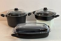 Overview of all three pieces (rectangular pot, round pot, square dish) with lids