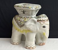 Front view of the ceramic elephant plant stand showing detailed floral painting and face.