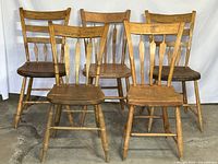 Set of five antique arrowback chairs with solid wood construction and varying wear shown, arranged in two rows.