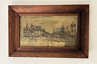 Framed etching artwork showing a detailed cityscape in a wooden frame with patina