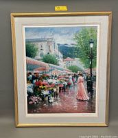 Framed lithograph showing colorful flower market scene with people and flower stalls, signed by artist Chun.