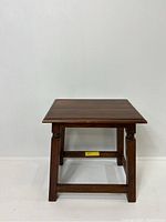 Front angle view of the vintage small wooden table showing the flat rectangular top and sturdy structure with crossbars.
