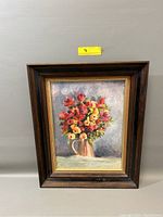 Frontal photo of the vintage still life floral oil painting in frame.