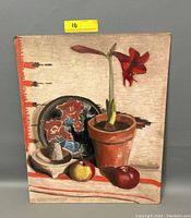 Front view of the vintage still life oil painting on board depicting fruits, flowers, a decorative plate, and mortar and pestle on a striped cloth