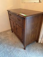 Front and side view of cherrywood buffet with two drawers and cabinet doors, showing wood grain and brass hardware.
