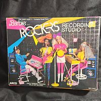 View of front of the original Barbie and The Rockers Recording Studio box showing doll models with musical instruments and studio setup.