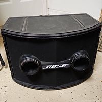 Front view of Bose 802 loudspeaker showing dual bass reflex ports and Bose logo.