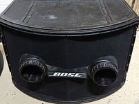 Front view of the Bose 802 loudspeaker showing the black curved cabinet with two front ports and Bose branding between them.