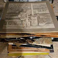 Stack of assorted vintage vinyl records showing visible wear and aging, with the top record being the Marshall Tucker Band album 'Where We All Belong'.