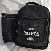 Front view of black Patron branded picnic backpack showing logo and attached cooler compartment