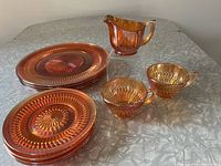 Full set on table showing four 6.25 in plates, four 10 in plates, two teacups, and one creamer.