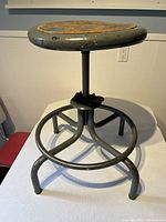 Side view of the Croydon industrial metal stool showing the sturdy curved legs and swivel mechanism beneath the seat.