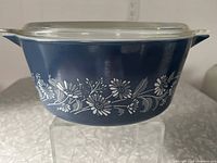 Front view of blue Pyrex casserole showing floral pattern and handle