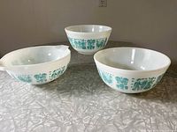 Three Pyrex Butterprint bowls grouped together showing pattern and size variation.