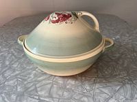 Full side view of covered serving dish showing tiger lily pattern on conical lid and dual handles on dish body