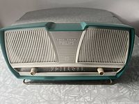 Front view of the turquoise Twin-Tone Philips radio showing speaker grilles, branding, tuning scale, and knobs.
