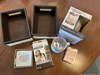 Photo showing two small woven storage boxes, Better Homes and Gardens fragrance warmer in box, one small candle or tealight holder, a card pack 'The Daily Mood', and a small tile with quote.