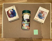 Photo of the rotating puzzle board with three puzzle boxes on top: Kaayee Yin Yang Owl, National Parks vintage puzzle, Charming Fox.
