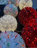 Close-up of various LED star light spheres in white, red, and multicolor with star-shaped protrusions and embedded LED bulbs.