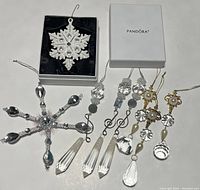 Boxed Pandora ceramic snowflake ornament alongside large silver snowflake and six assorted crystal and pearl-like hanging ornaments