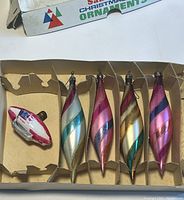 All four flame-shaped glass ornaments and one American flag zeppelin-shaped lightbulb in original cardboard box